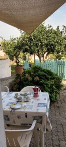 Zona pranzo all'aperto della mini suite familiare , ombreggiata con vela, vista giardino. Immersi nella natura