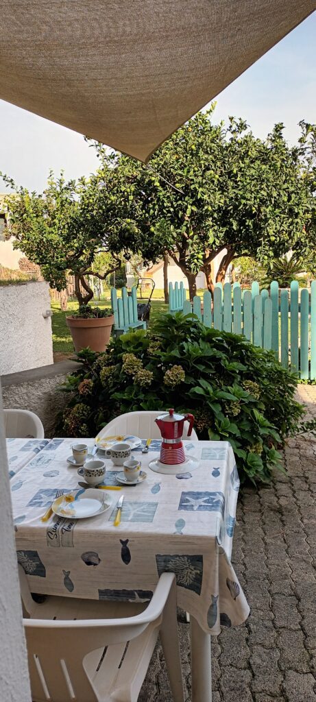 Zona pranzo all'aperto , ombreggiata con vela, vista giardino. Immersi nella natura